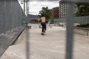 Shirtless skateboarder pushing through the skatepark at Pier 25