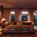 Hotels Above Par feature on The Greenwich Hotel. Key image featuring a wide view of the living space and rustic natural wood table in the TriBeCa Penthouse