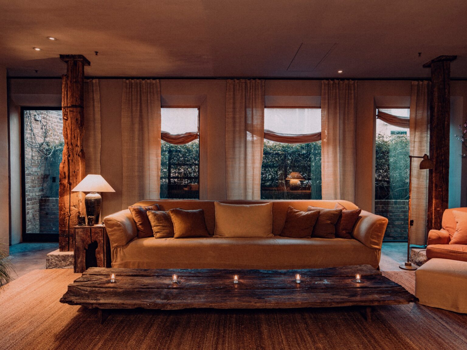 Hotels Above Par feature on The Greenwich Hotel. Key image featuring a wide view of the living space and rustic natural wood table in the TriBeCa Penthouse